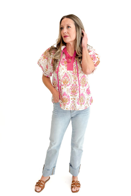 Front view of woman wearing Pink &amp; Tan Paisley Printed Top by Entro with jeans against white studio background.