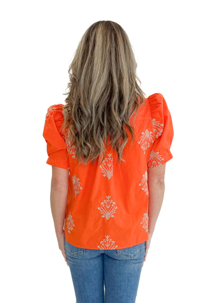 Back view of woman wearing Orange Embroidered Button Up Top by Entro with jeans against white studio background.