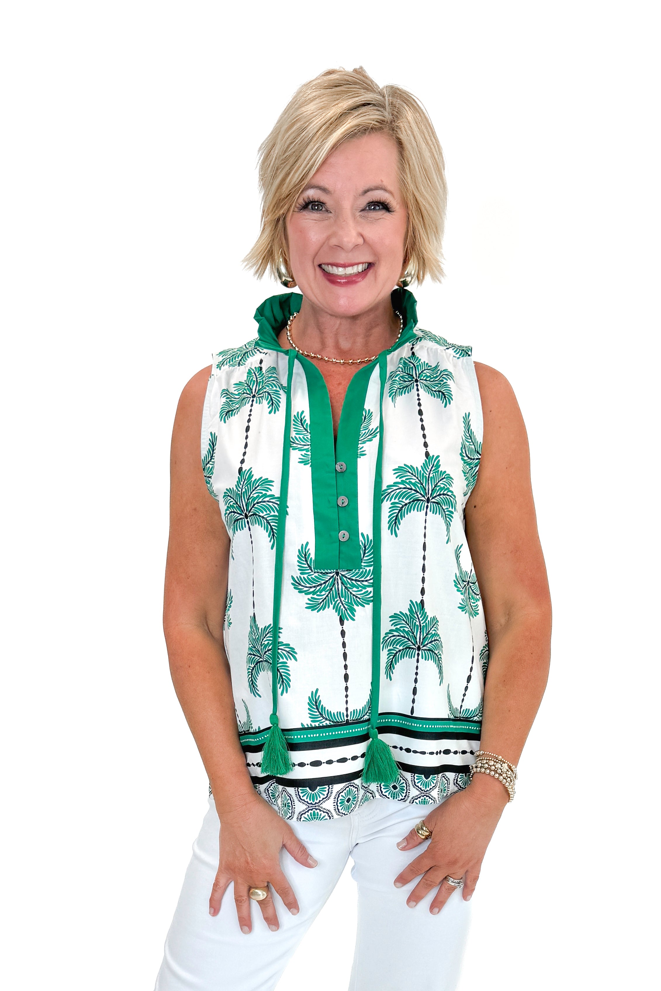 Front view of woman wearing Green Palm Printed Sleeveless Top by Entro with jeans against white studio background.