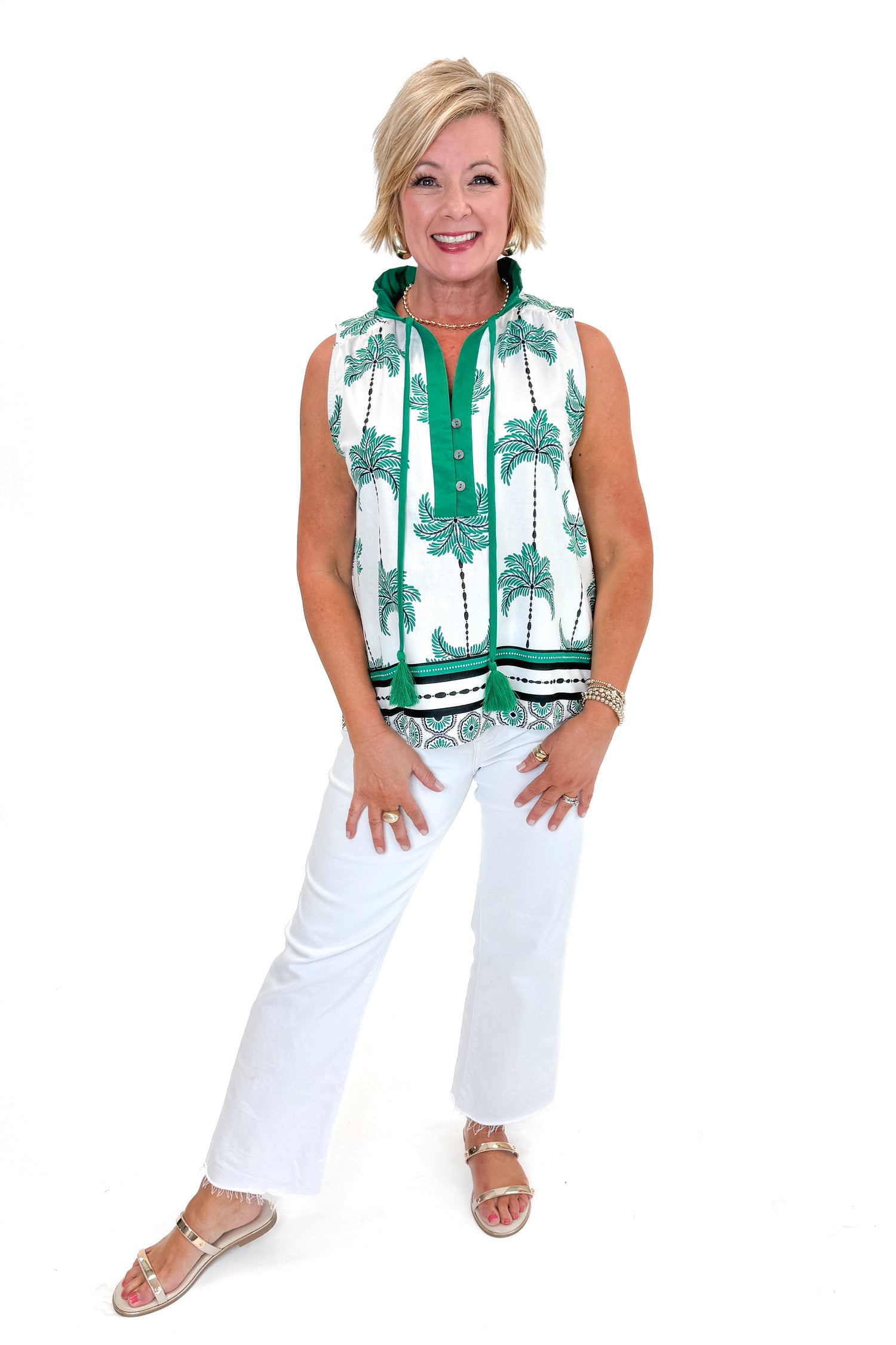 Front view of woman wearing Green Palm Printed Sleeveless Top by Entro with jeans against white studio background.