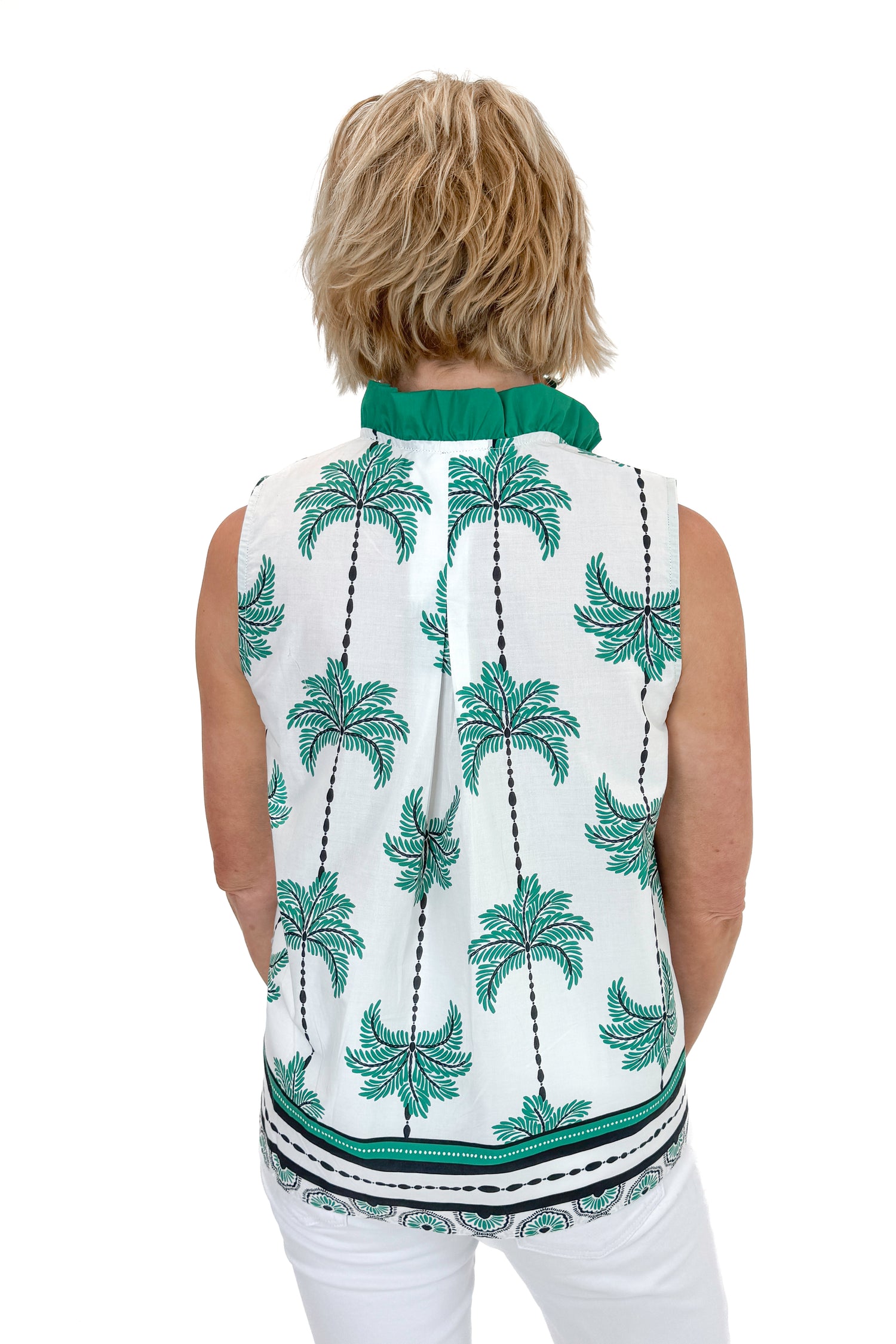 Back view of woman wearing Green Palm Printed Sleeveless Top by Entro with jeans against white studio background.
