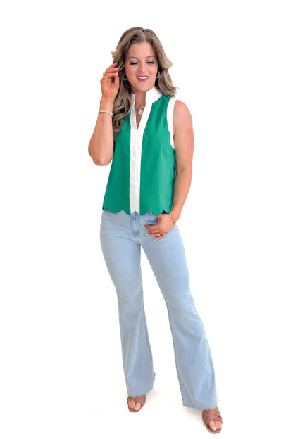 Front view of woman wearing Green Scallop Hem Center Stripe Tank by Entro with jeans against white studio background.