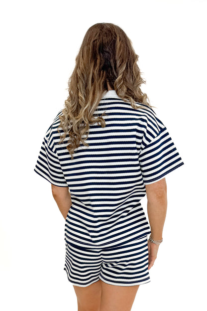 Back view of woman wearing Navy &amp; White Striped Shorts by Entro with matching Navy &amp; White Striped Collared Top by Entro against white studio background.