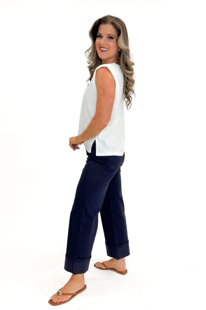 Side view of woman wearing Off White Ribbed Center Seam Tank by Entro with jeans against white studio background.