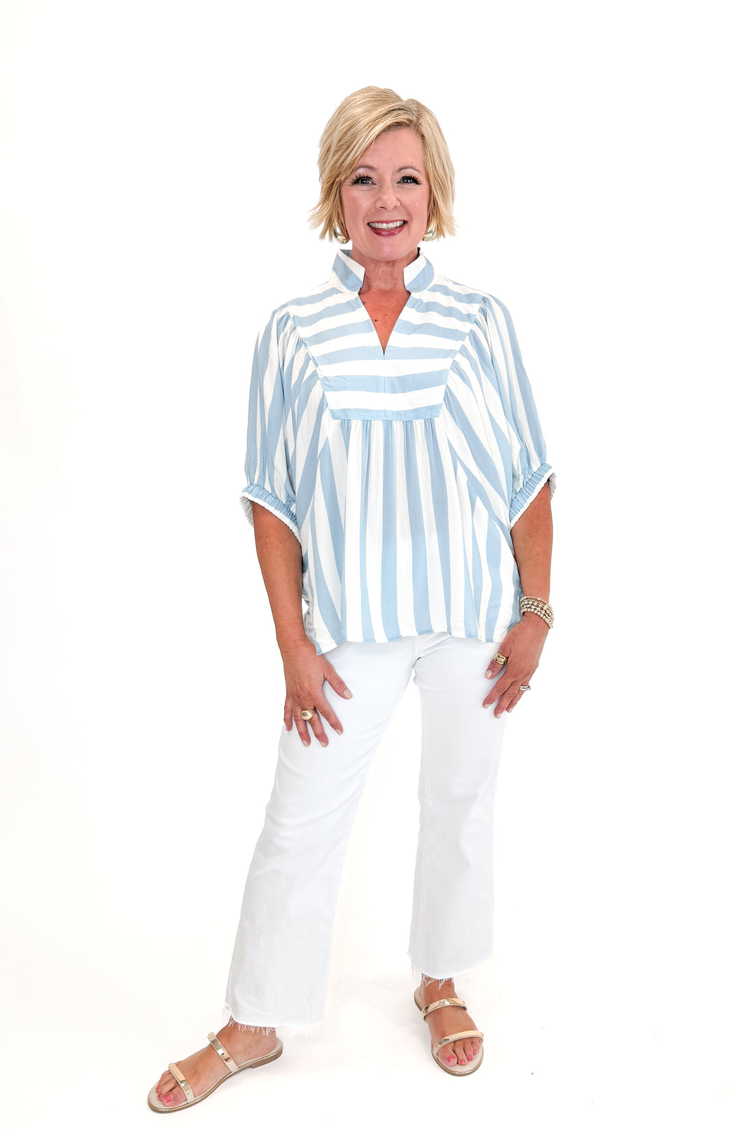Front view of woman wearing Light Blue Stripe Detail V-Neck Top by Entro with jeans against white studio background.