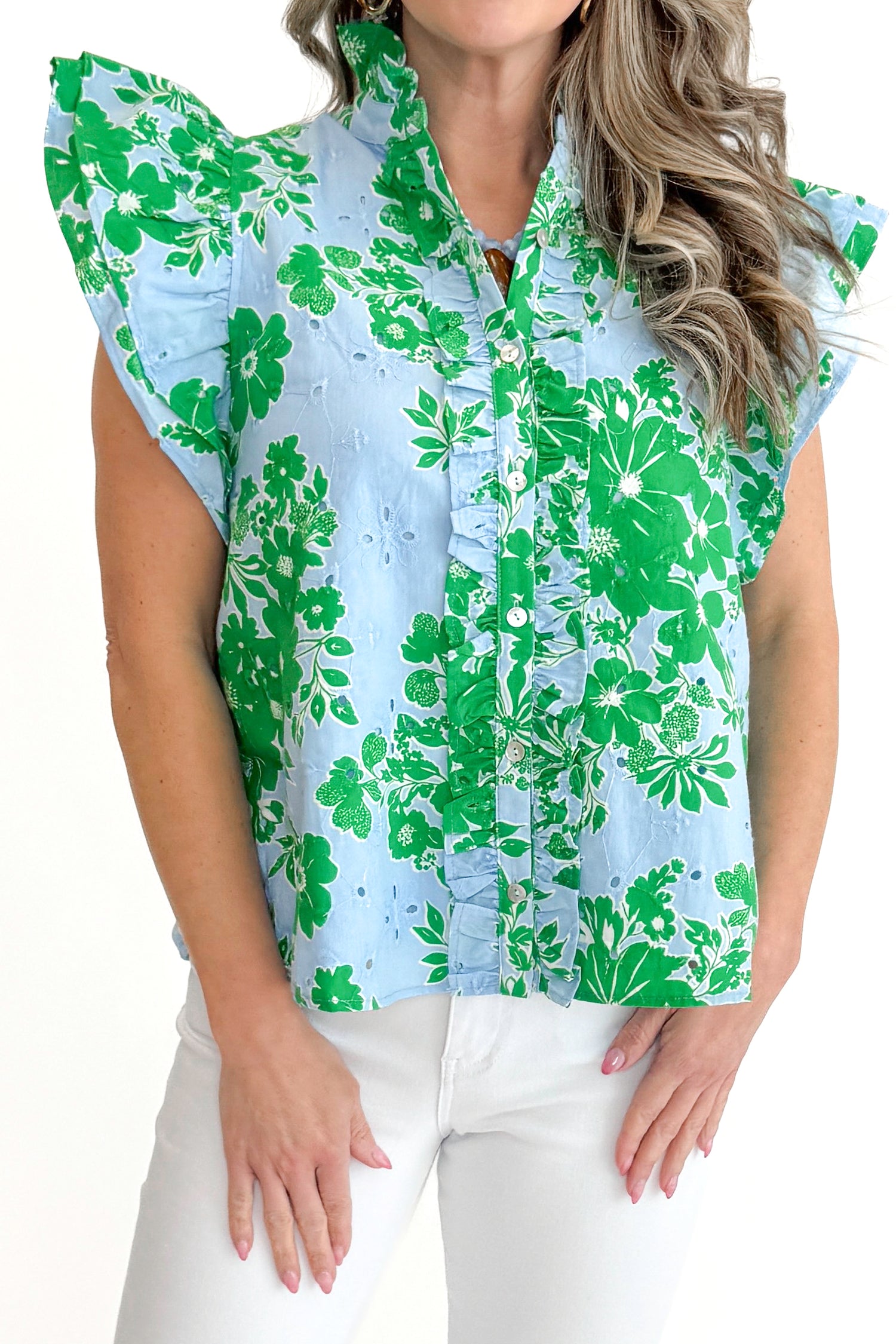 Front detail view of woman wearing Green &amp; Blue Floral Eyelet Top by Entro with white jeans against white studio background.