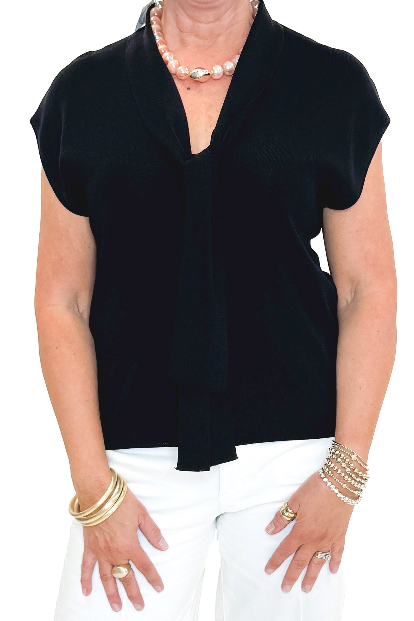 Front detail view of woman wearing Black Faux Layered Sweater Tank by Entro with jeans against white studio background.