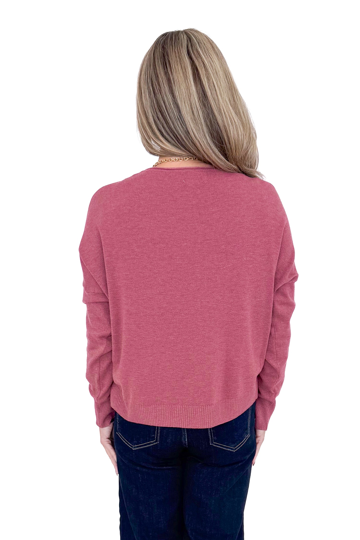 Back view of woman wearing Heathered Berry Center Seam Sweater and blue jeans. 