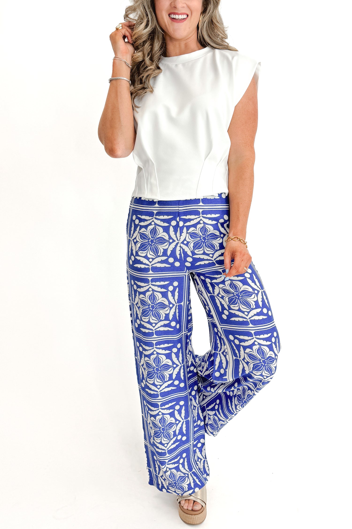 Front view of woman wearing Blue Floral Print Wide Leg Pants with top against white studio background.