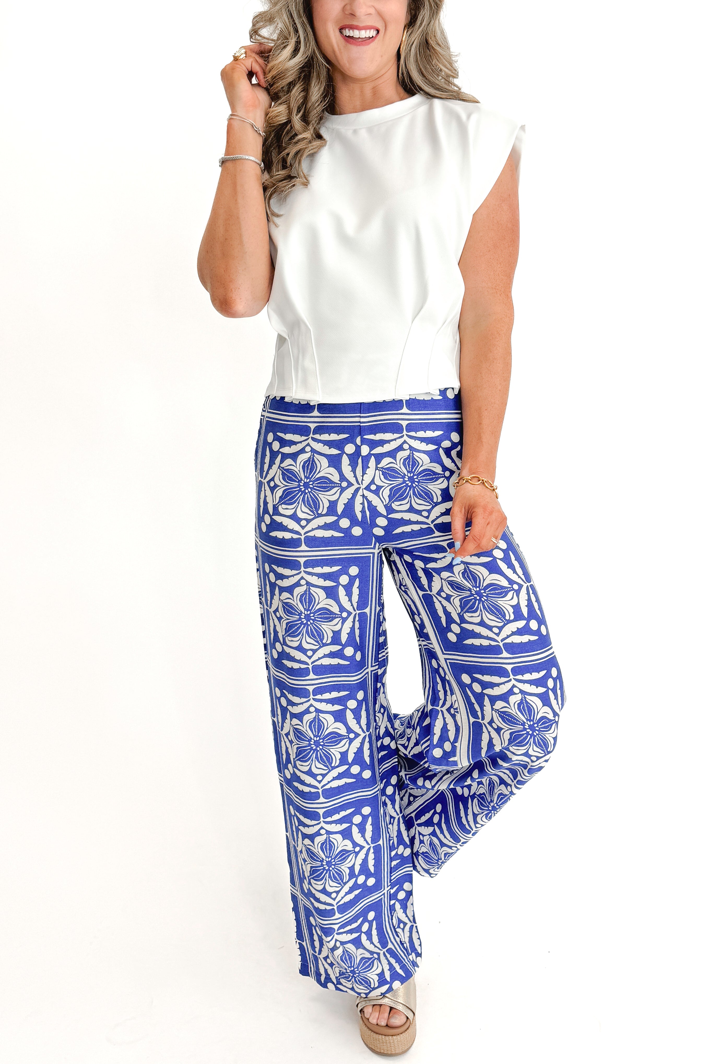 Front view of woman wearing Blue Floral Print Wide Leg Pants with top against white studio background.