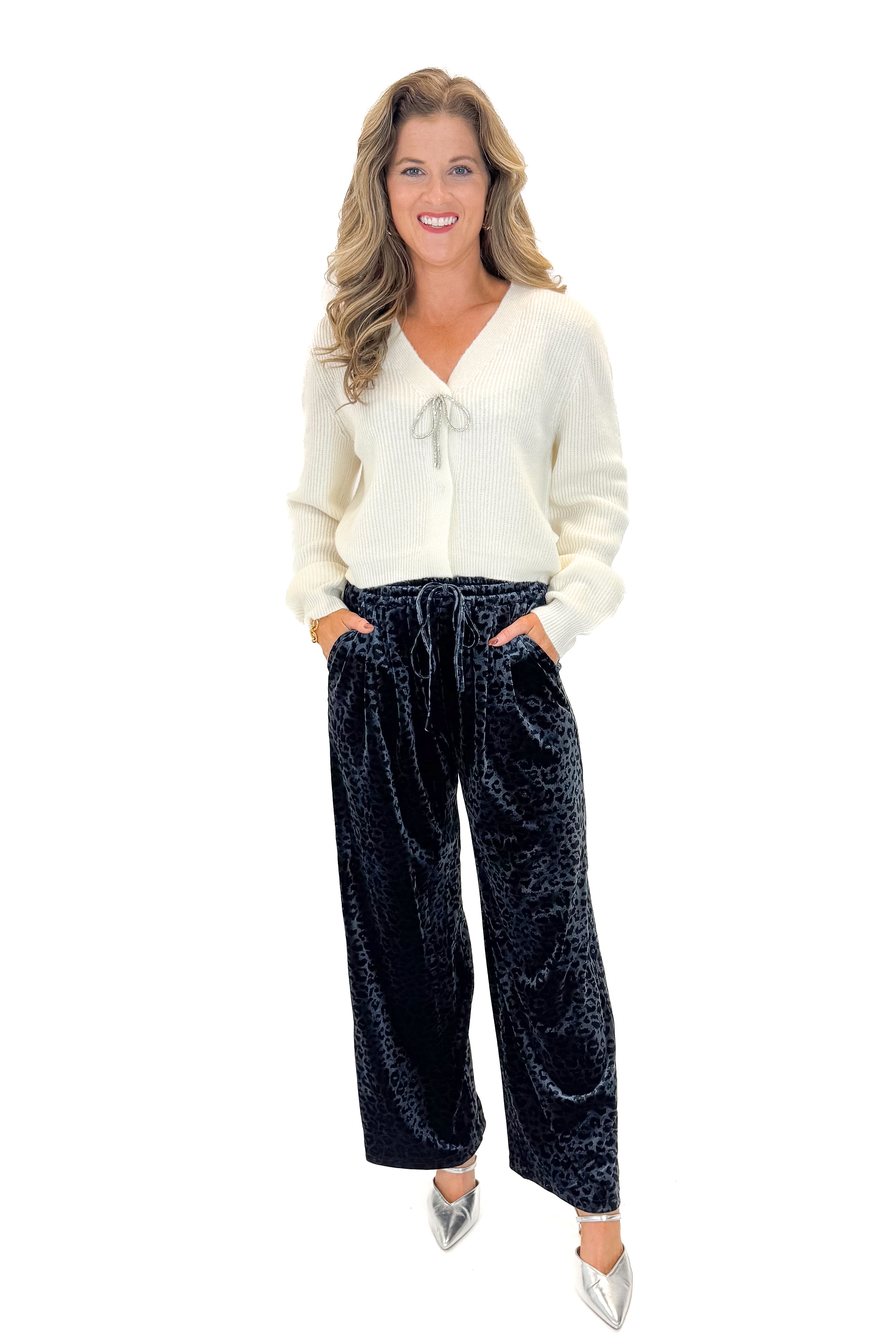 Front view of woman wearing Navy Velvet Leopard Print Pants with sweater against white studio background.
