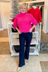 Front view of woman wearing Hot Pink Ribbed Turtleneck Sweater with jeans at a boutique.