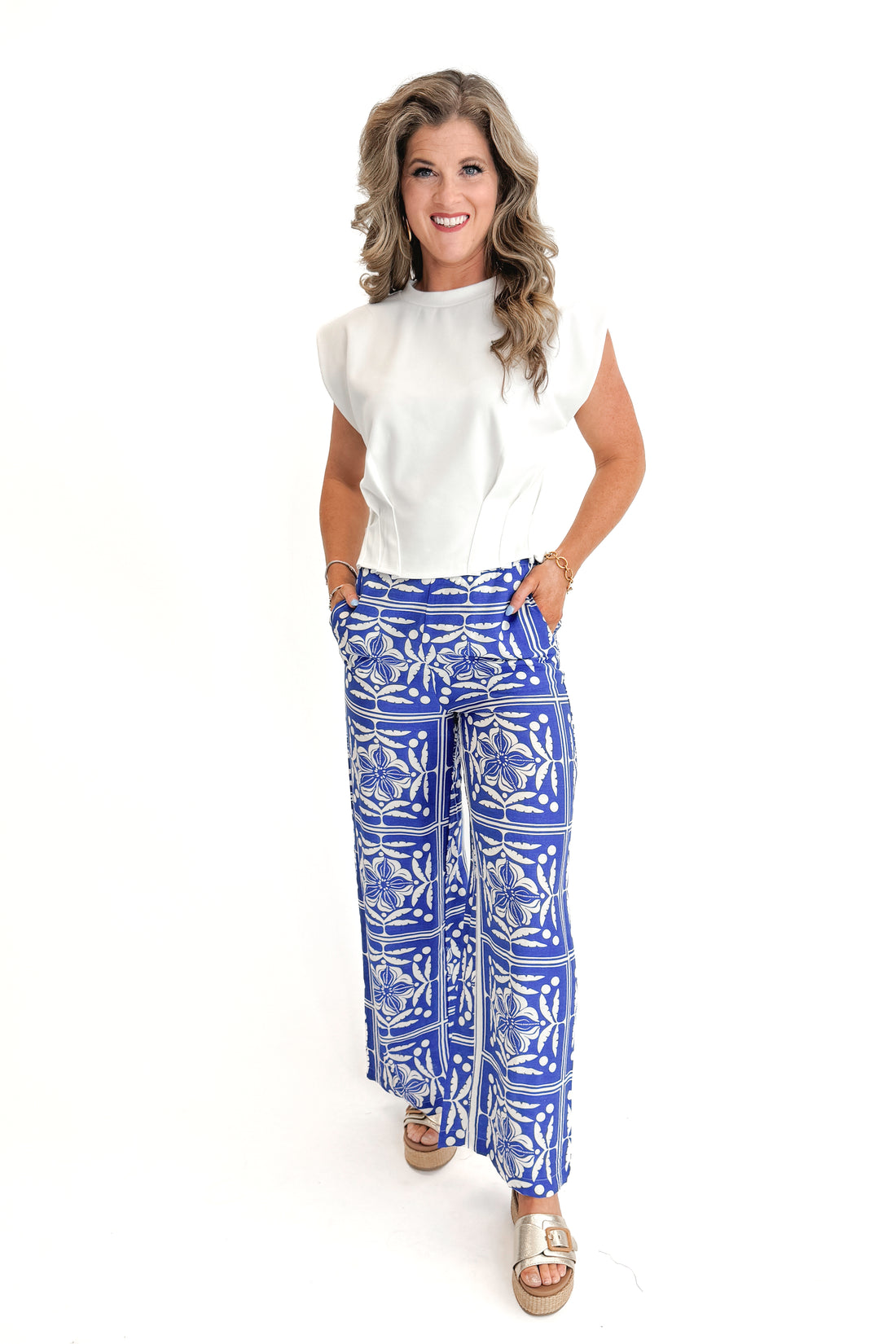 Front view of woman wearing Blue Floral Print Wide Leg Pants with top against white studio background.