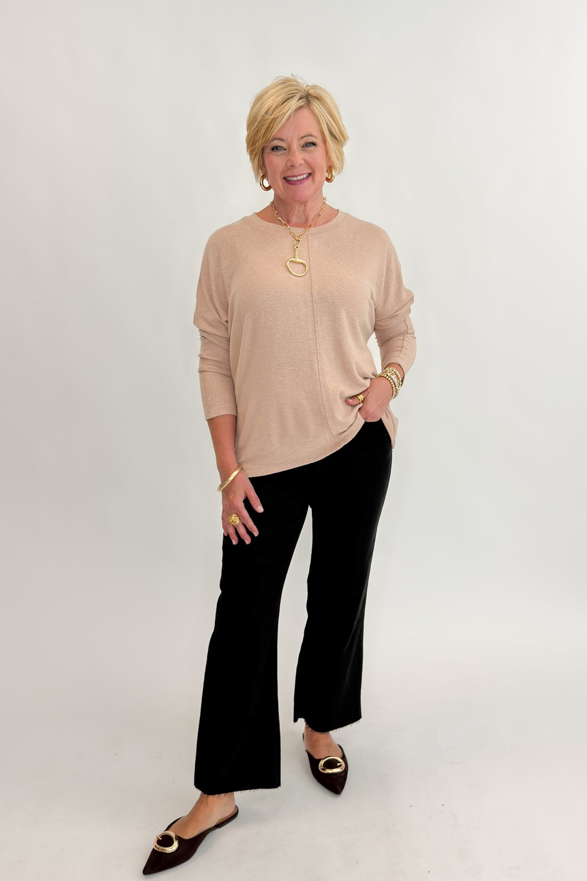 Front view of woman wearing Swagger Boutique’s Taupe Brushed Center Seam Top with jeans against white studio background.