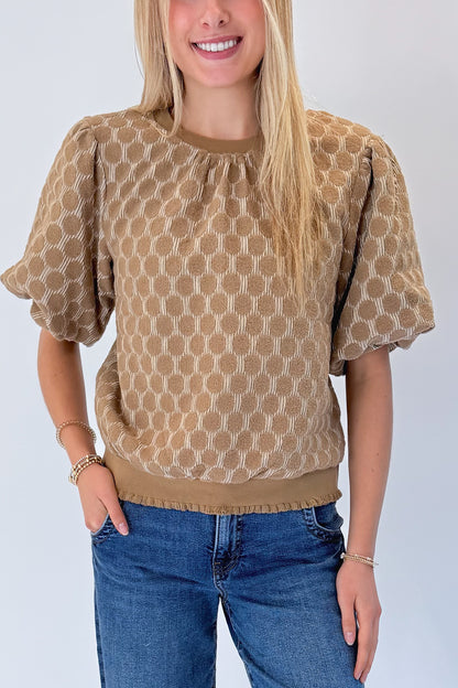 Front detail view of woman wearing Swagger Boutique’s Taupe Polka Dot Textured Top with jeans against white studio background.