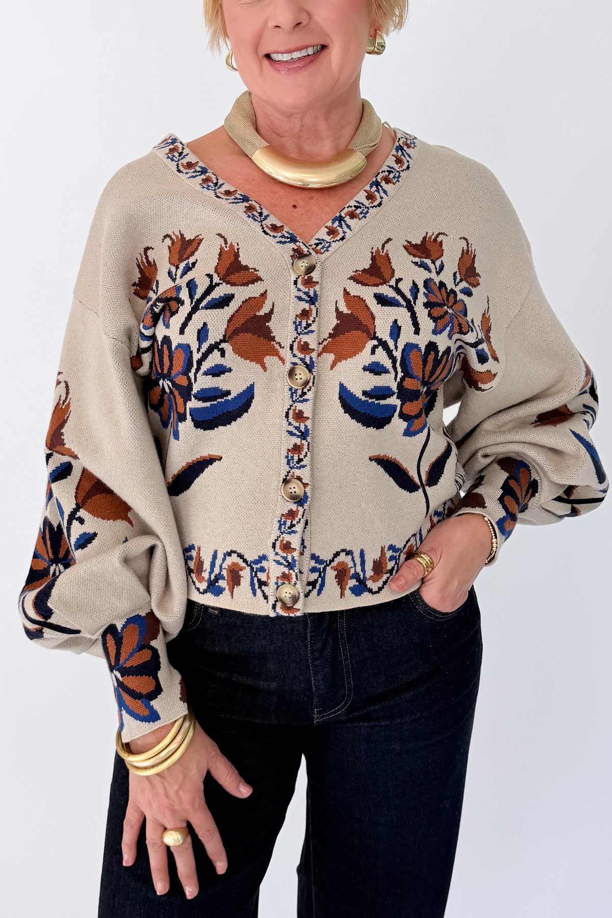 Front detail view of woman wearing Swagger Boutique’s Taupe Printed V-Neck Cardigan with jeans against white studio background.