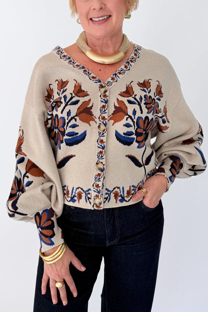 Front detail view of woman wearing Swagger Boutique’s Taupe Printed V-Neck Cardigan with jeans against white studio background.