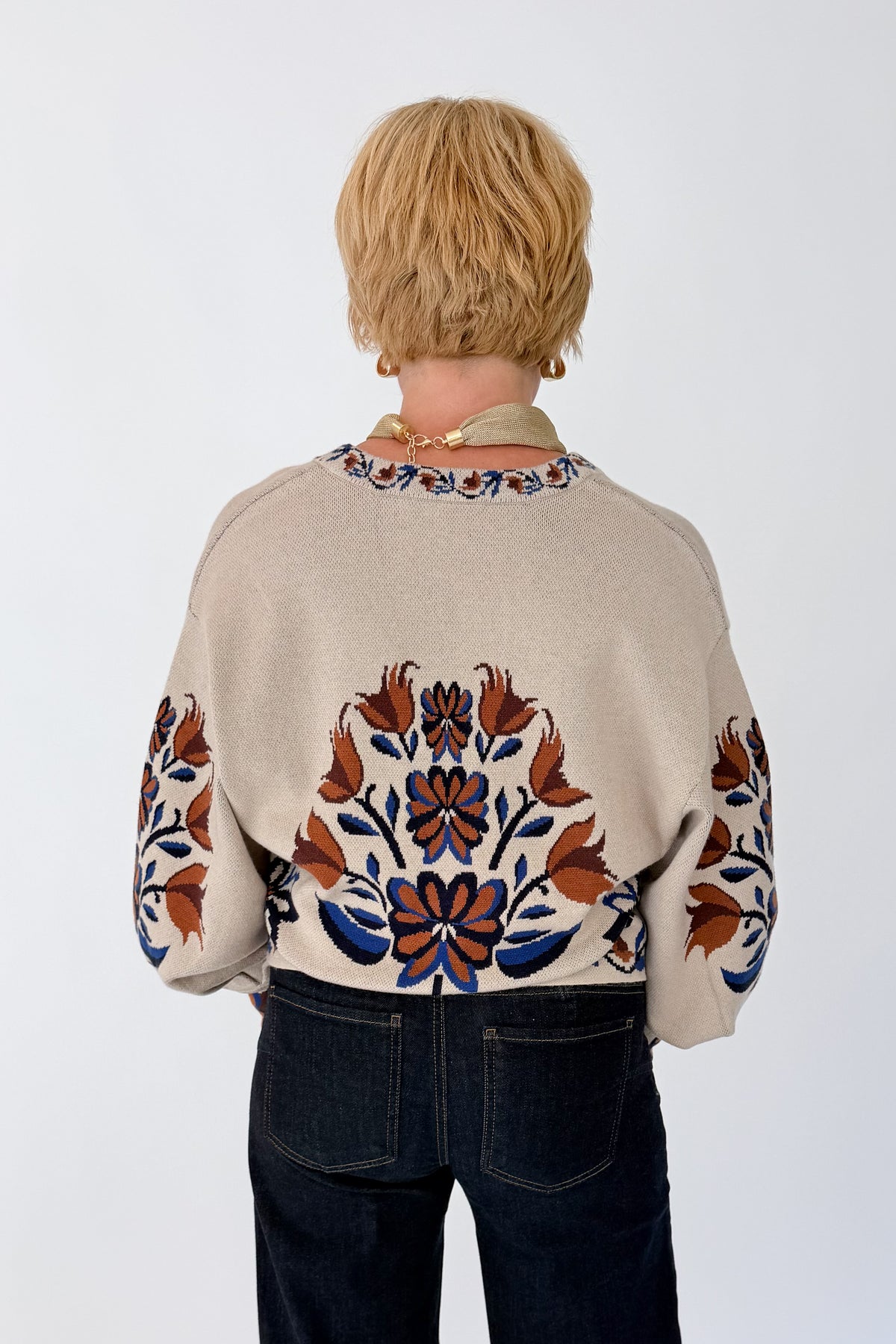 Back view of woman wearing Swagger Boutique’s Taupe Printed V-Neck Cardigan with jeans against white studio background.