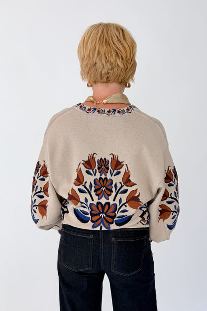 Back view of woman wearing Swagger Boutique’s Taupe Printed V-Neck Cardigan with jeans against white studio background.
