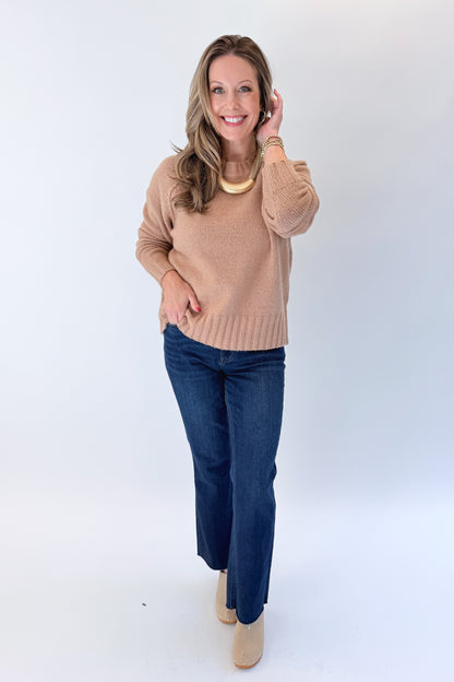 Front view of woman wearing Swagger Boutique’s Taupe Ribbed Hem Sweater with jeans against white studio background.