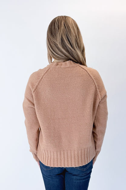 Back view of woman wearing Swagger Boutique’s Taupe Ribbed Hem Sweater with jeans against white studio background.