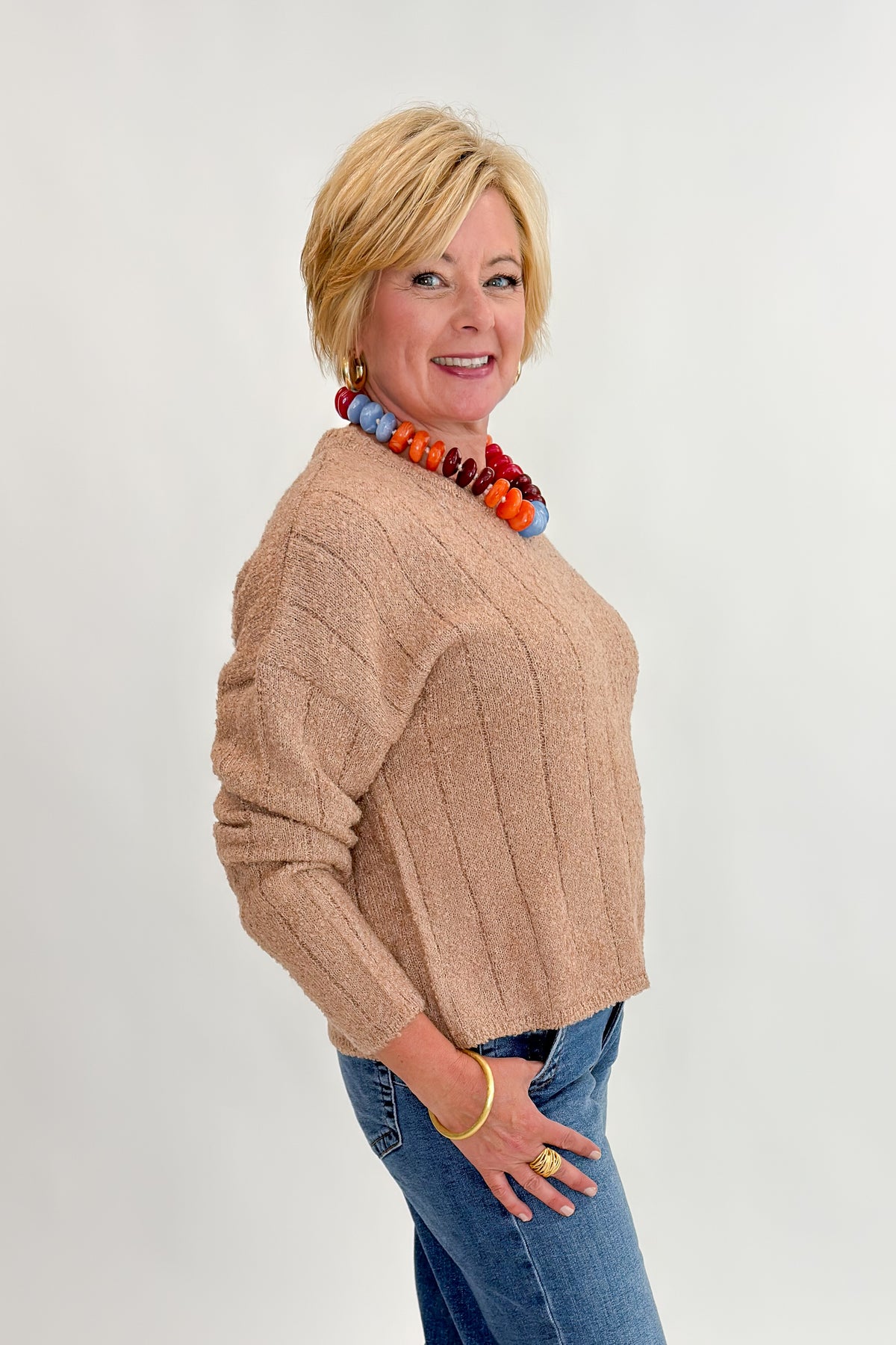 Side view of woman wearing Swagger Boutique’s Taupe Ribbed Textured Sweater with Maya Wide Leg Jeans In Medium Wash- Journey by Kut from the Kloth against white studio background.