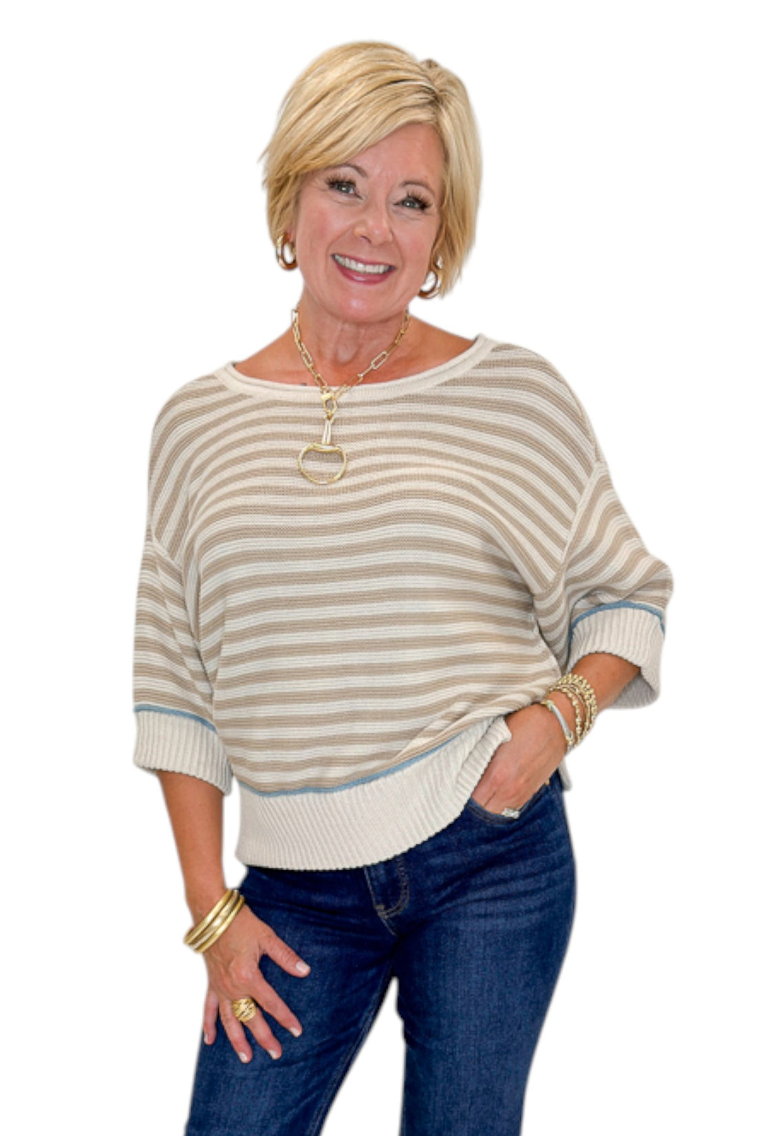 Front view of woman wearing Swagger Boutique’s Taupe Striped Short Sleeve Sweater with jeans against white studio background.