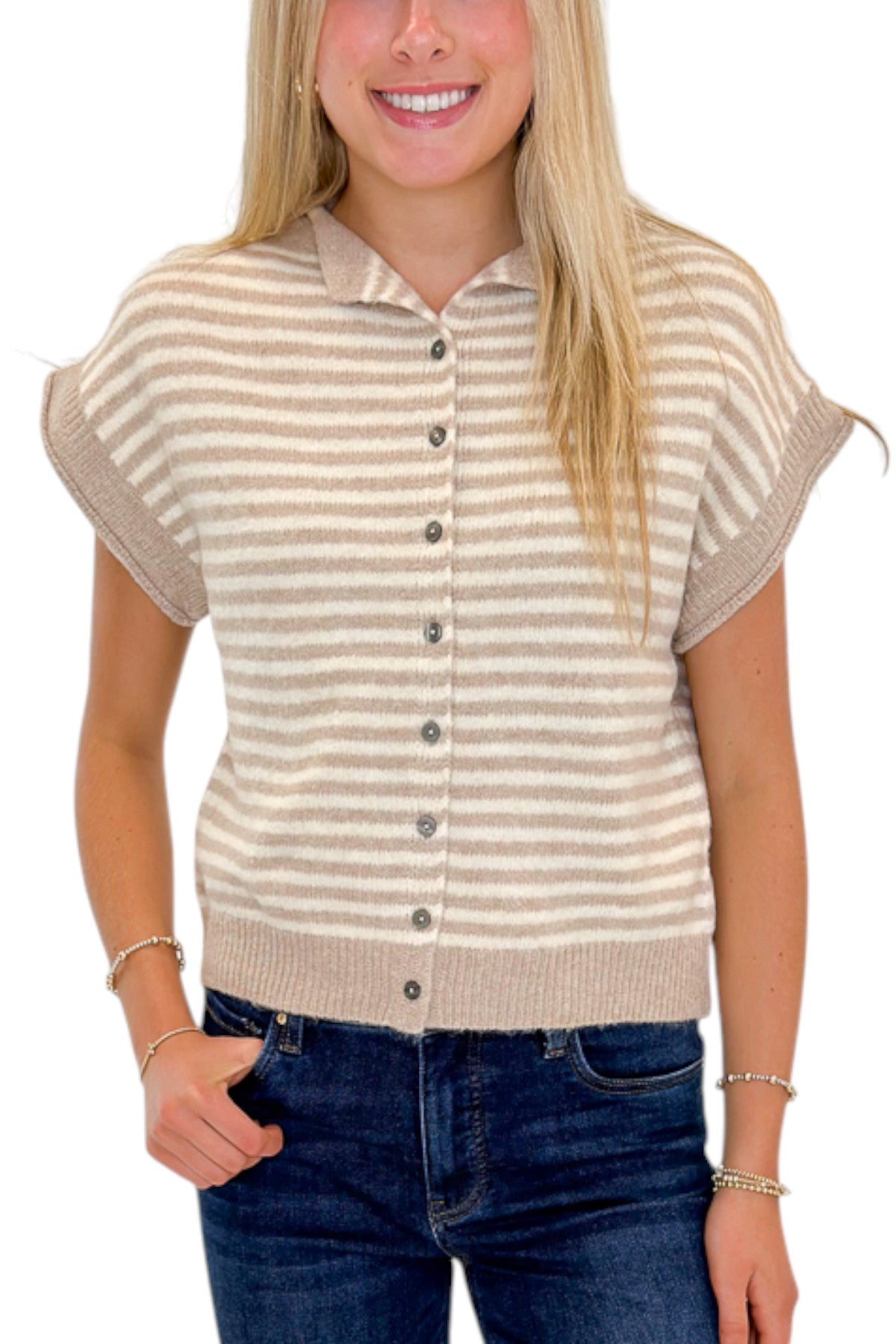 Front detail view of woman wearing Swagger Boutique’s Taupe &amp; Cream Striped Sleeveless Sweater by Entro with jeans against white studio background.
