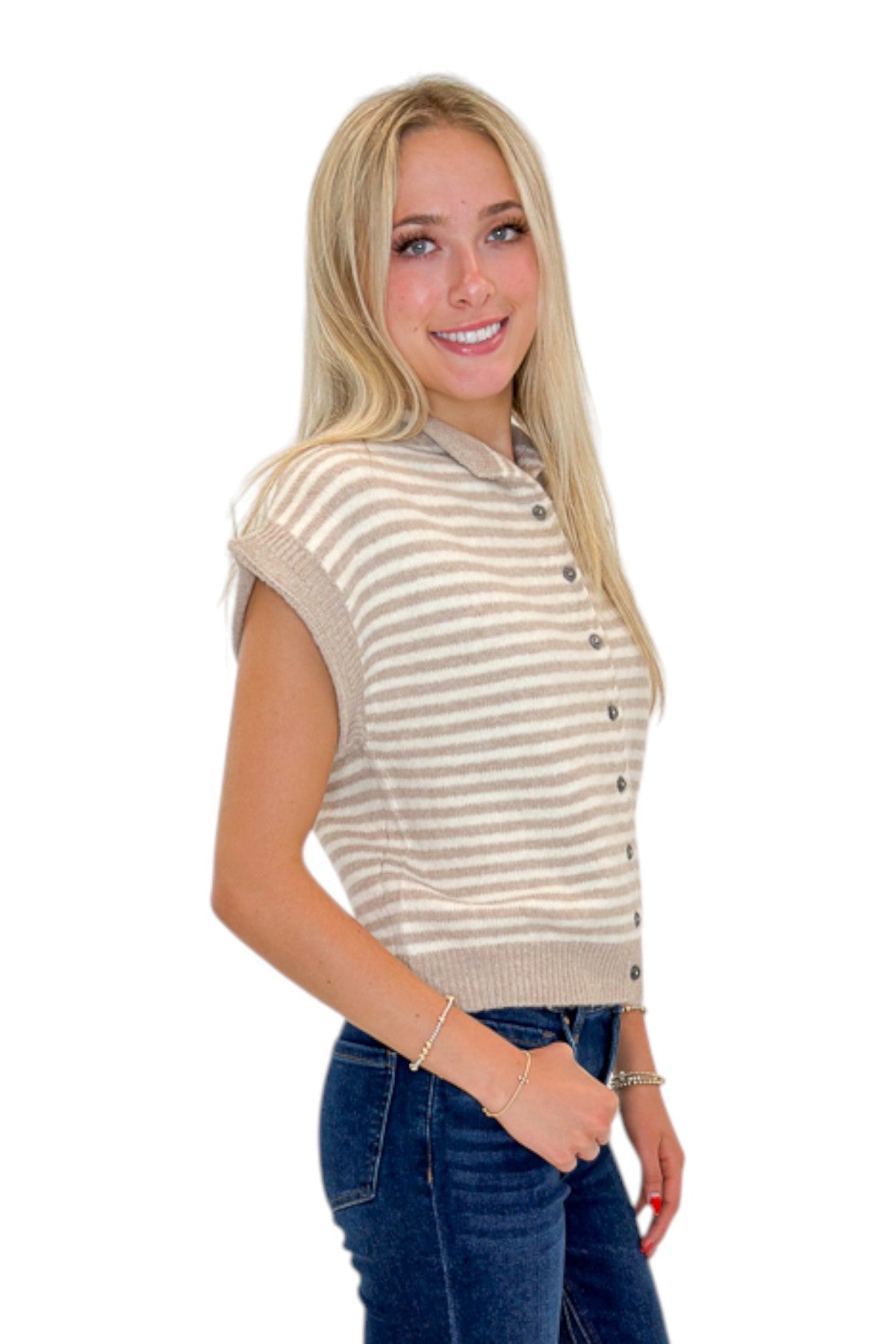 Side view of woman wearing Swagger Boutique’s Taupe &amp; Cream Striped Sleeveless Sweater by Entro with jeans against white studio background.
