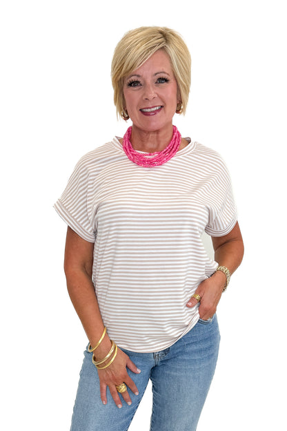 Front view of woman wearing Swagger Boutique’s Taupe &amp; White Striped Short Sleeve Top with jeans against white studio background.