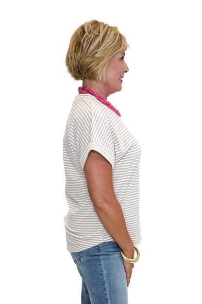 Side view of woman wearing Swagger Boutique’s Taupe &amp; White Striped Short Sleeve Top with jeans against white studio background.