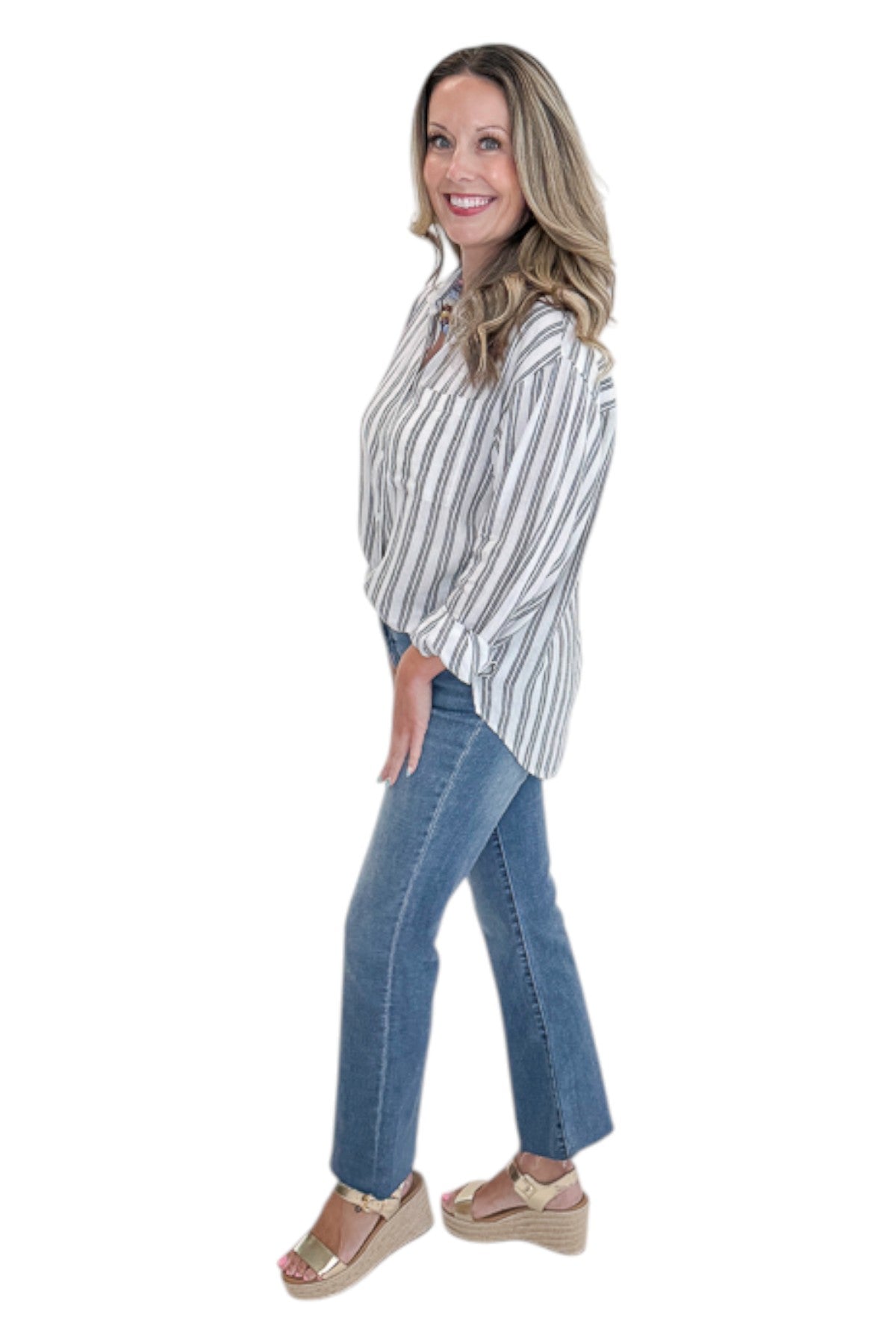 Side view of woman wearing Swagger Boutique’s White The Perfect Striped Button Up Top by Z Supply with jeans against white studio background.