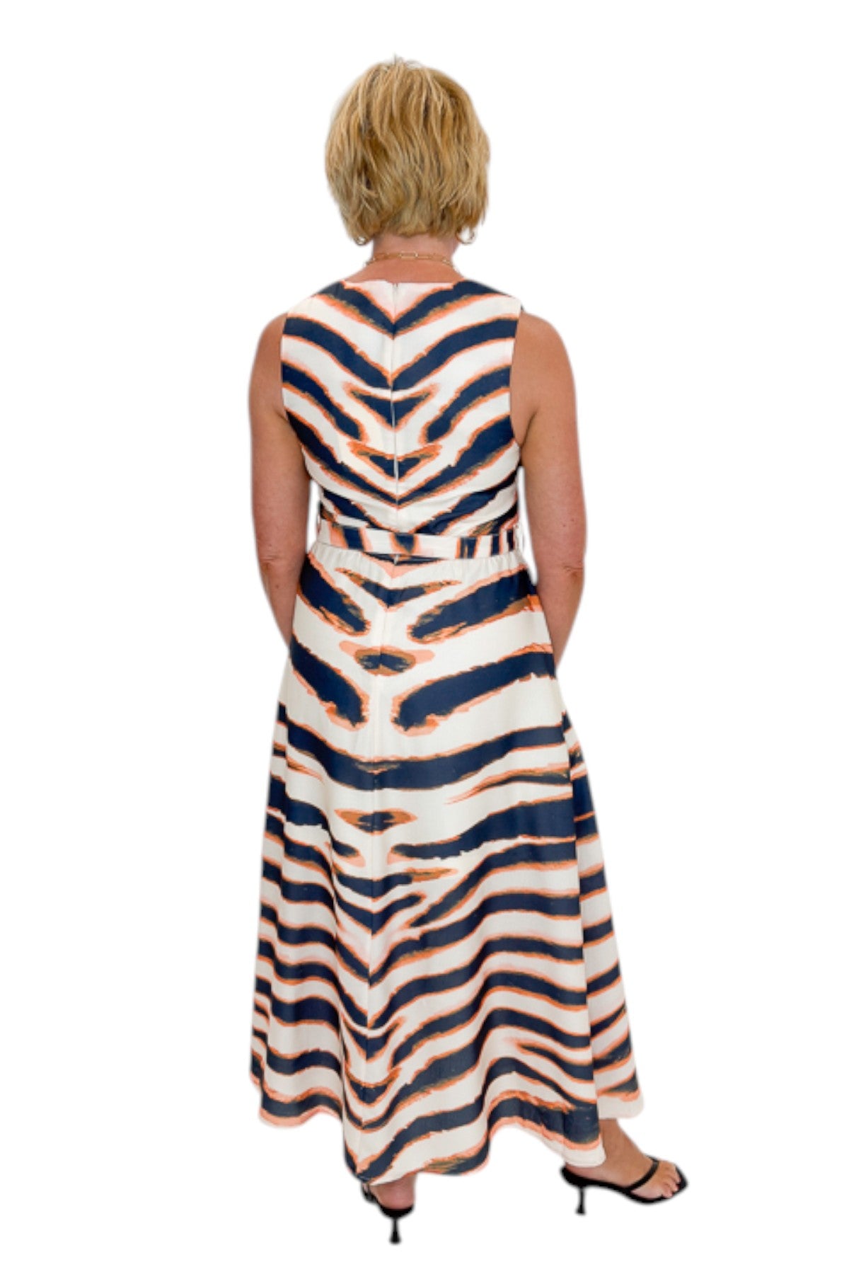 Back view of woman wearing Swagger Boutique’s Tiger Print Midi Dress by Entro with heels against white studio background.
