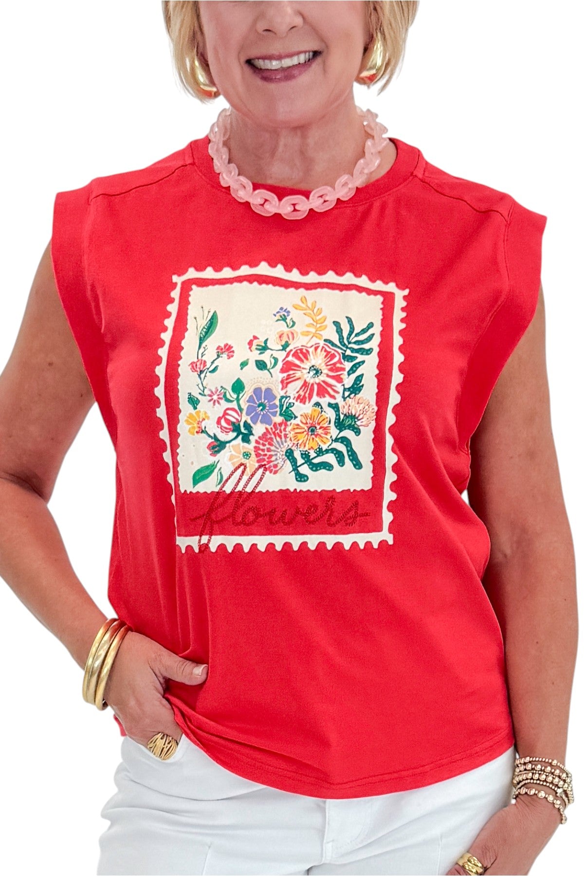 Front detail view of woman wearing Swagger Boutique’s Tomato Floral Graphic Tee with jeans against white studio background.