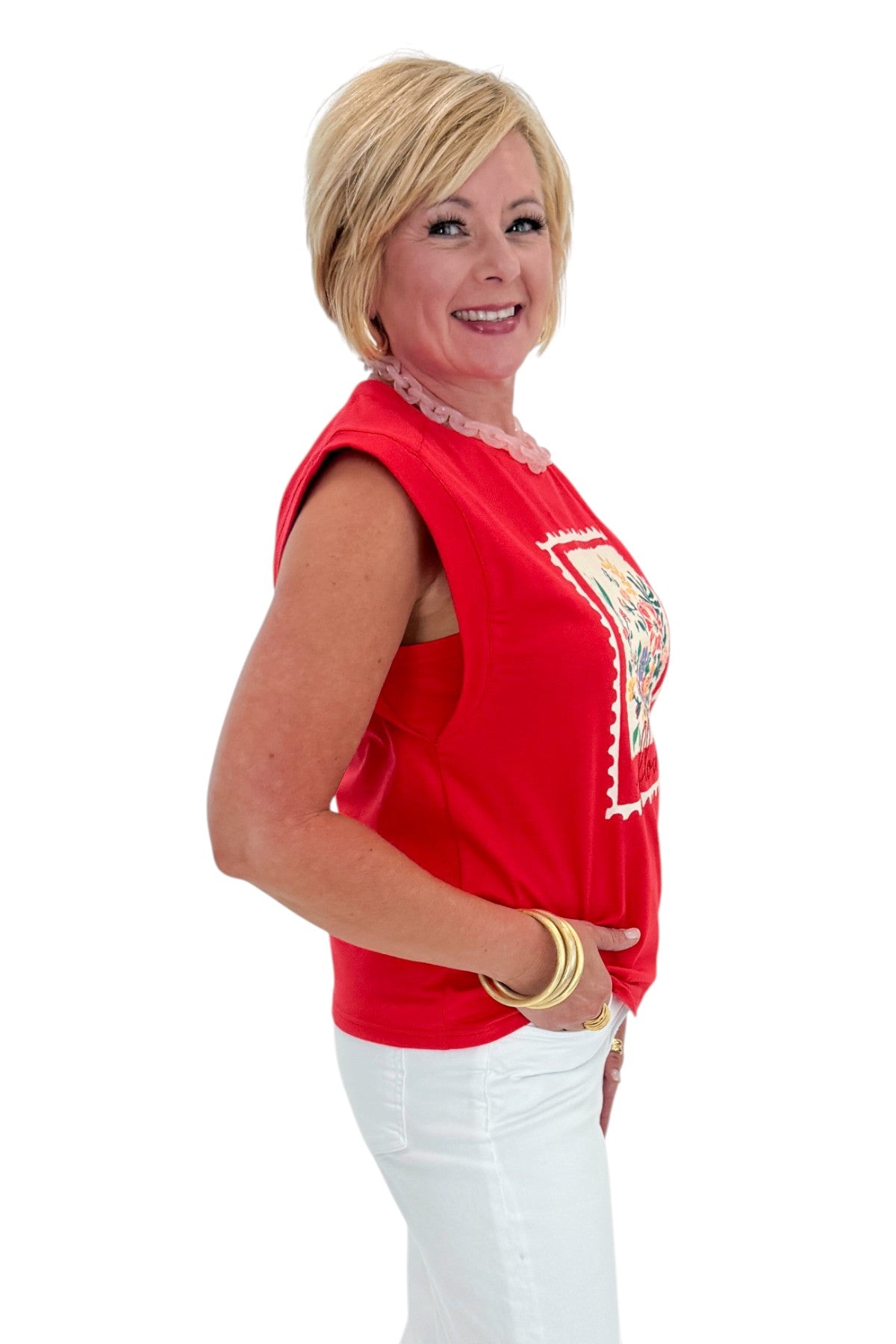 Side view of woman wearing Swagger Boutique’s Tomato Floral Graphic Tee with jeans against white studio background.