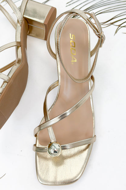 Tuari- Gold Ball Detail Cross Strap Heels against studio background