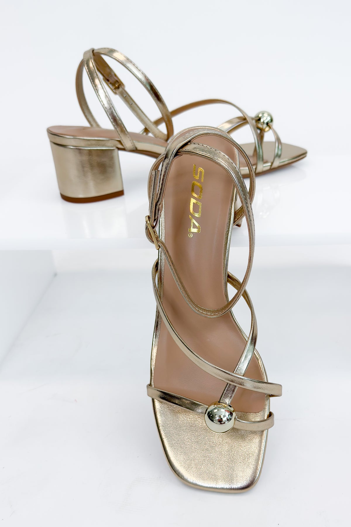 Tuari- Gold Ball Detail Cross Strap Heels against studio background