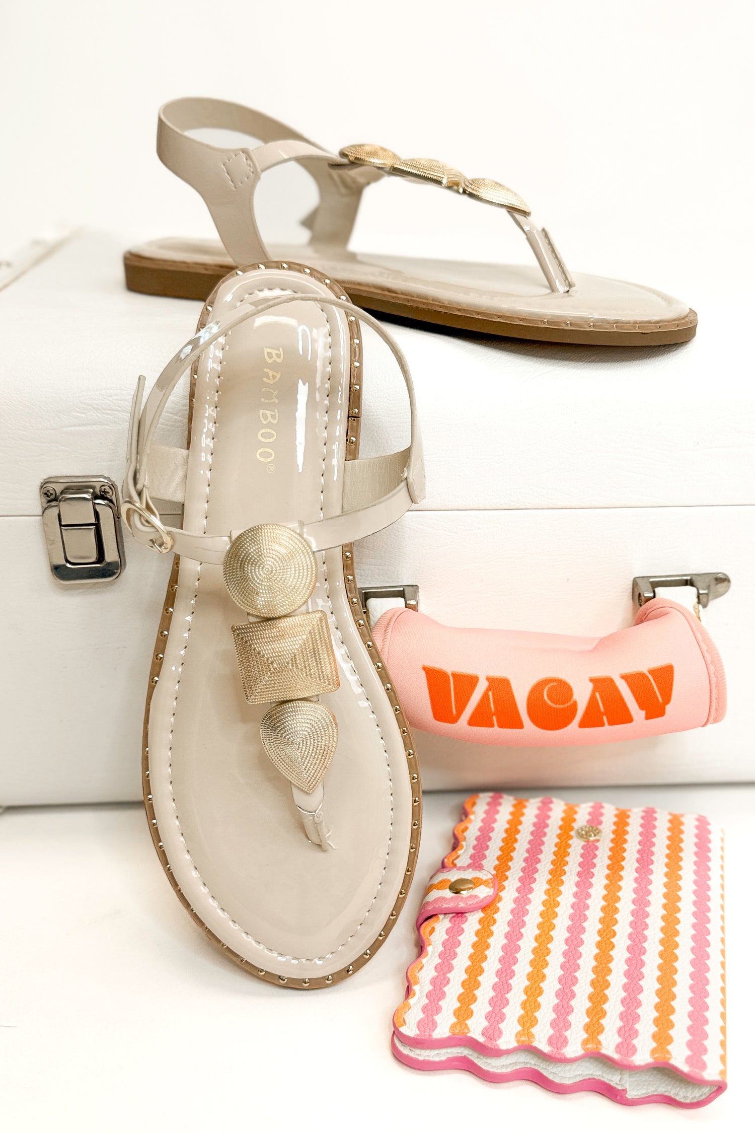 Twinkle- Bone With Gold Charms Sandal with travel accessories against white studio background front and side view.