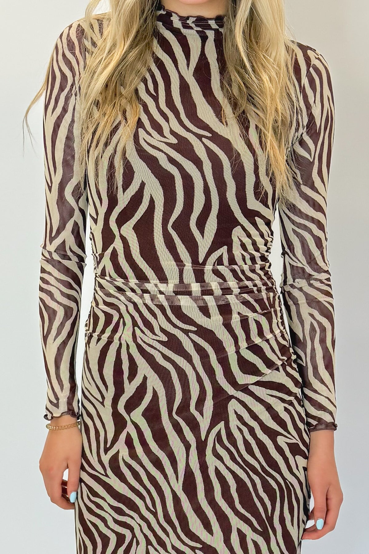 Front detail view of woman wearing Swagger Boutique’s Velvet Rouge Sevilla Zebra Mesh Midi Dress by Z Supply with heels against white studio background.