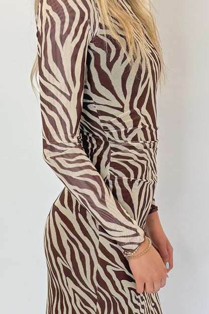 Side detail view of woman wearing Swagger Boutique’s Velvet Rouge Sevilla Zebra Mesh Midi Dress by Z Supply with heels against white studio background.