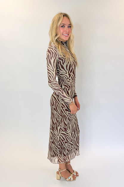 Side view of woman wearing Swagger Boutique’s Velvet Rouge Sevilla Zebra Mesh Midi Dress by Z Supply with heels against white studio background.