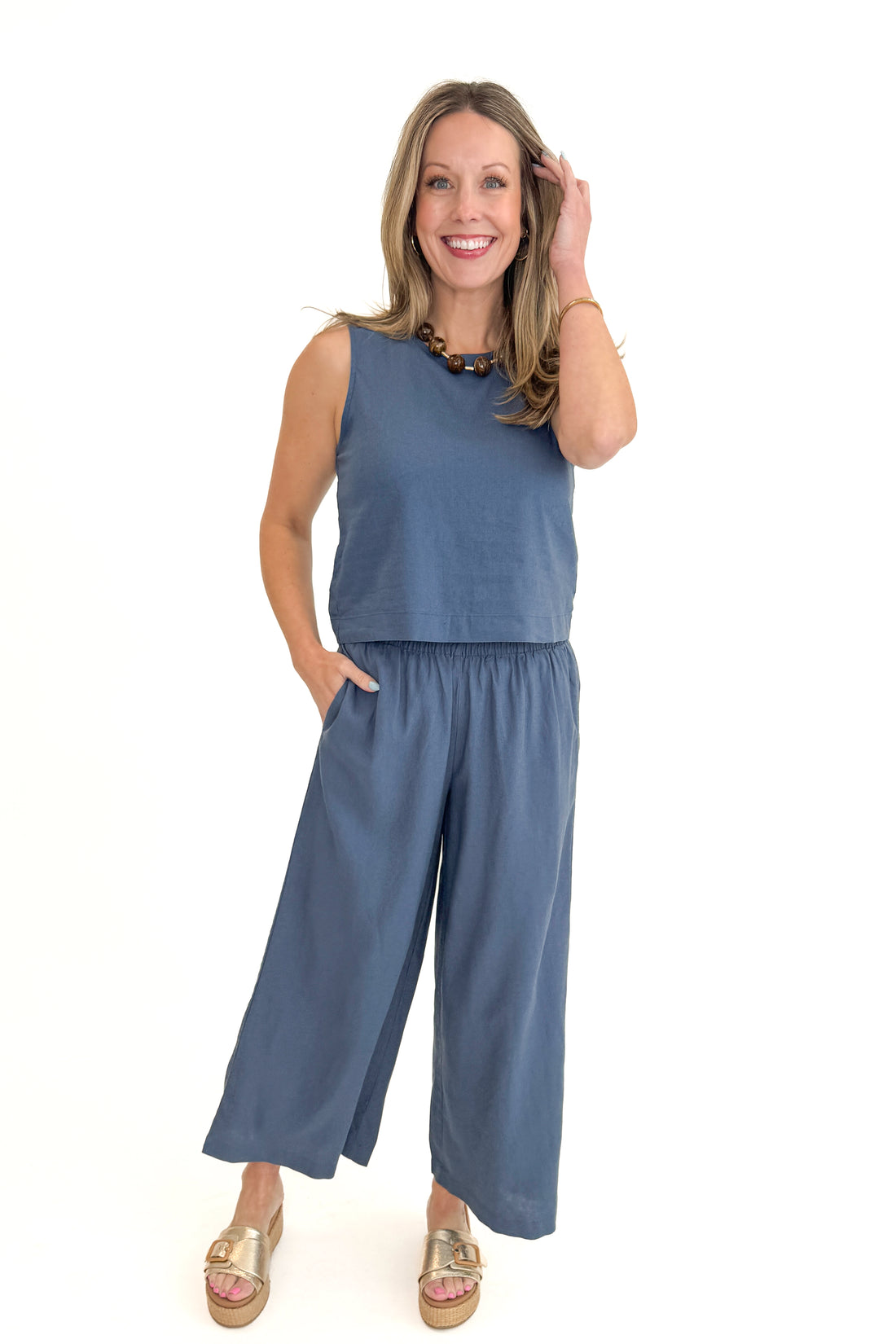 Front view of woman wearing Vintage Indigo Scout Linen Pants by Z Supply with matching Vintage Indigo Sloane Linen Top by Z Supply against white studio background.