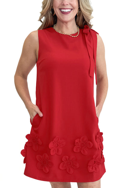 Front detail view of woman wearing Red With Floral Applique Shift Dress by THML against white studio background.
