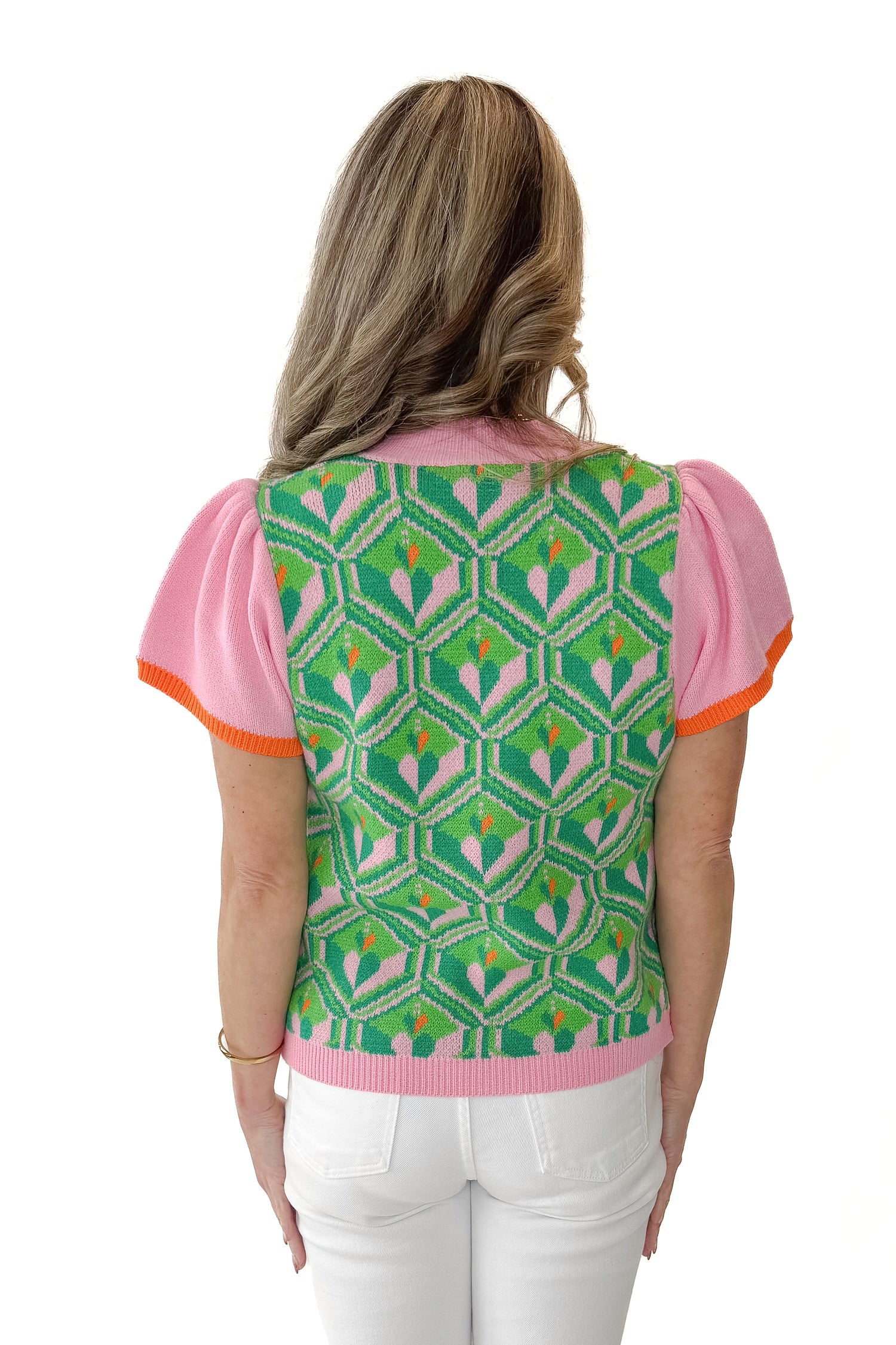 Back view of woman wearing Pink and Green Printed Short Sleeve Sweater with jeans against white studio background.
