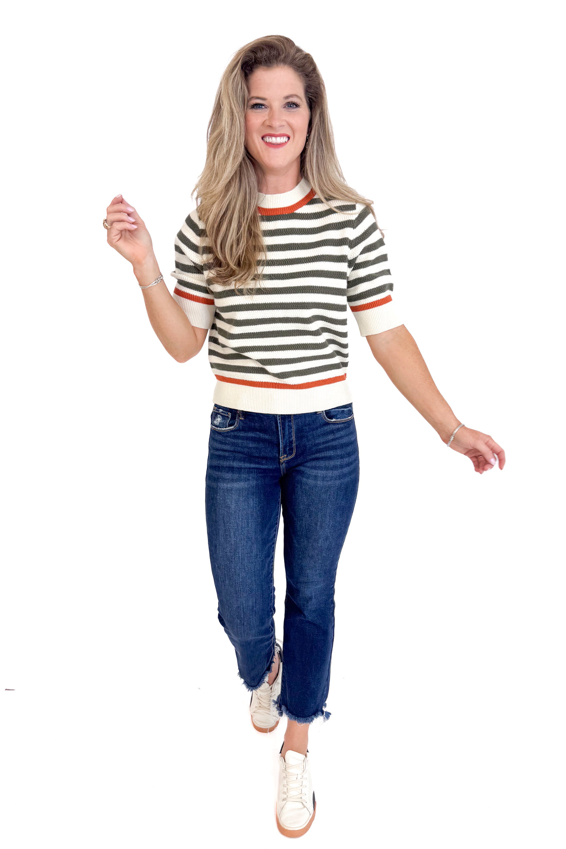 Woman wearing a striped shirt and jeans on a white background