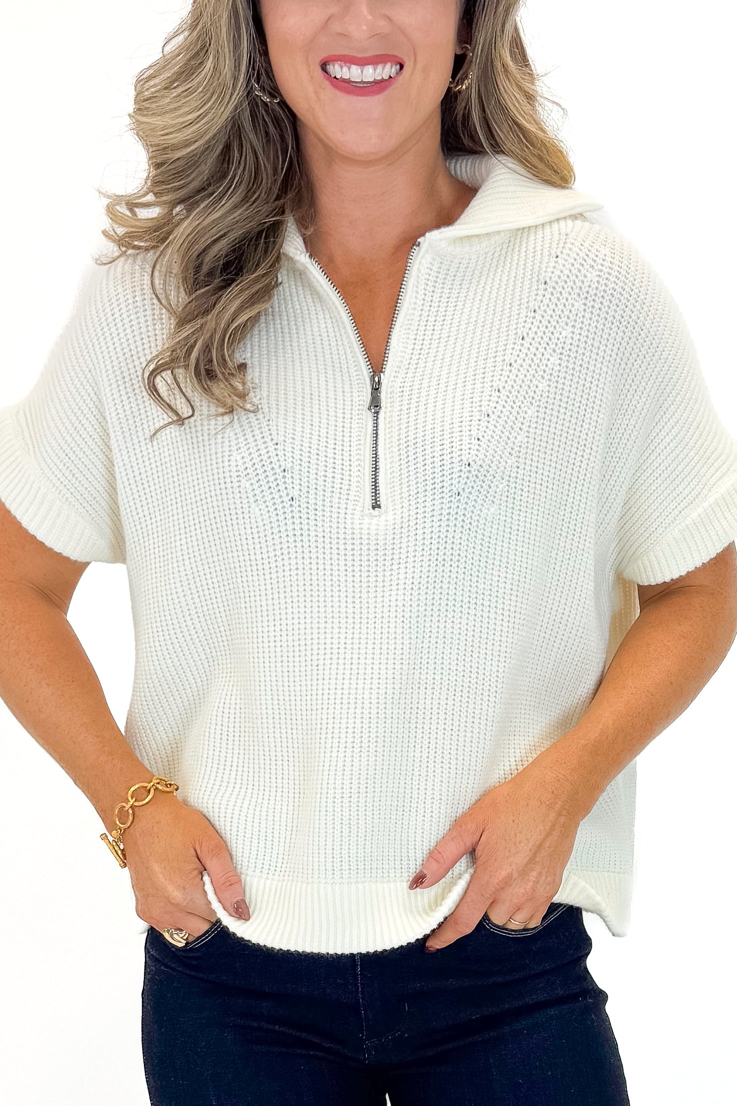 Front view of woman wearing Off White 1/2 Zip Short Sleeve Sweater with jeans against white studio background.