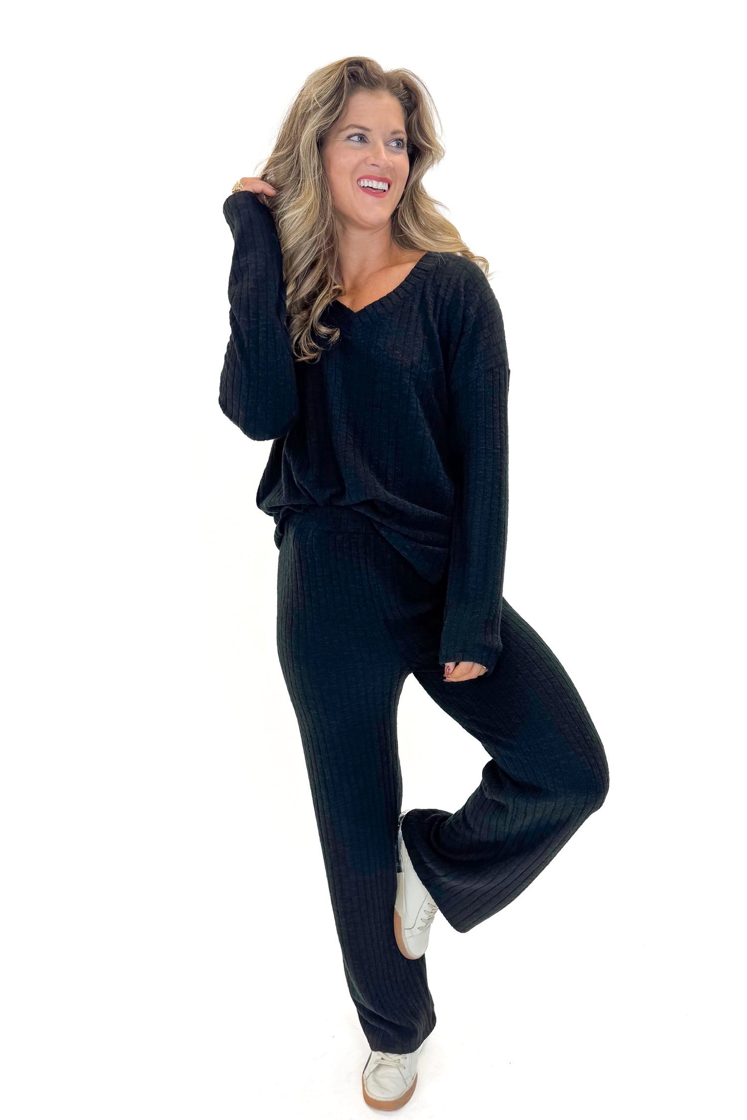 Front view of woman wearing Black Ribbed Lounge Pants with matching top against white studio background.