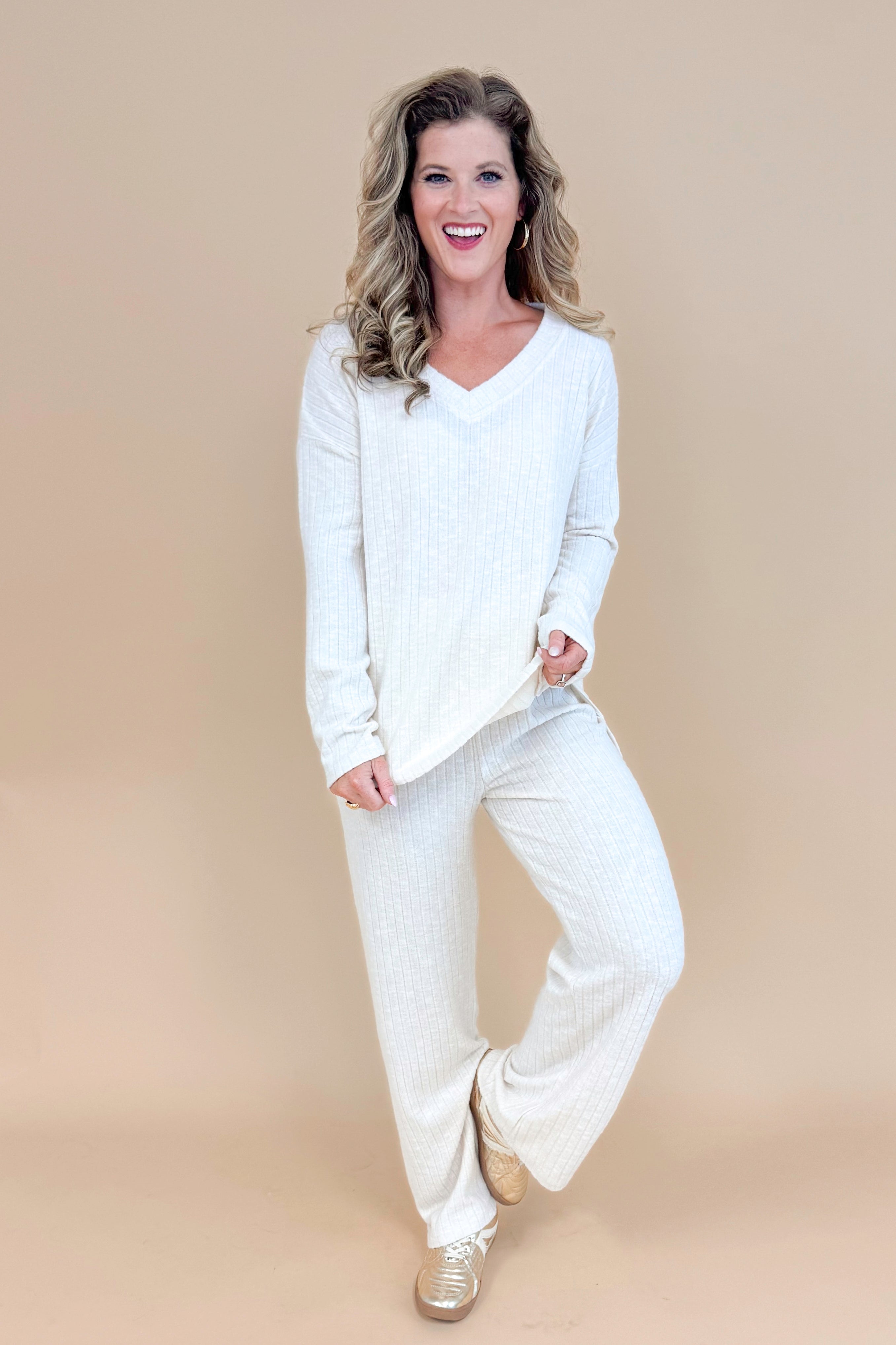 Model wearing cream ribbed lounge pants and matching long sleeve top.