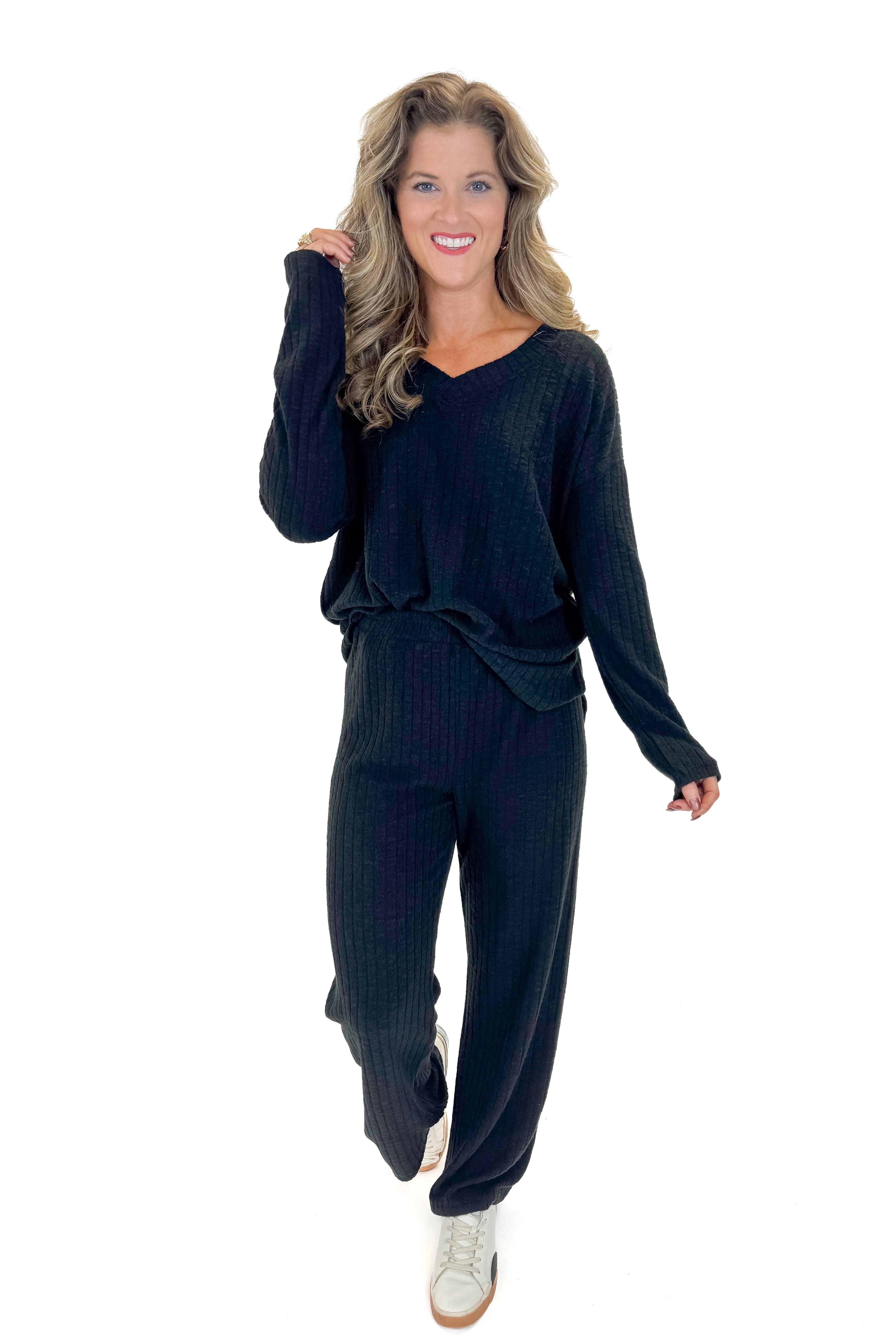 Front view of woman wearing Black Ribbed Lounge Pants with matching top against white studio background.
