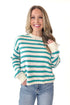 Front view of woman wearing Blue and Green Striped Sweater with jeans against white studio background.